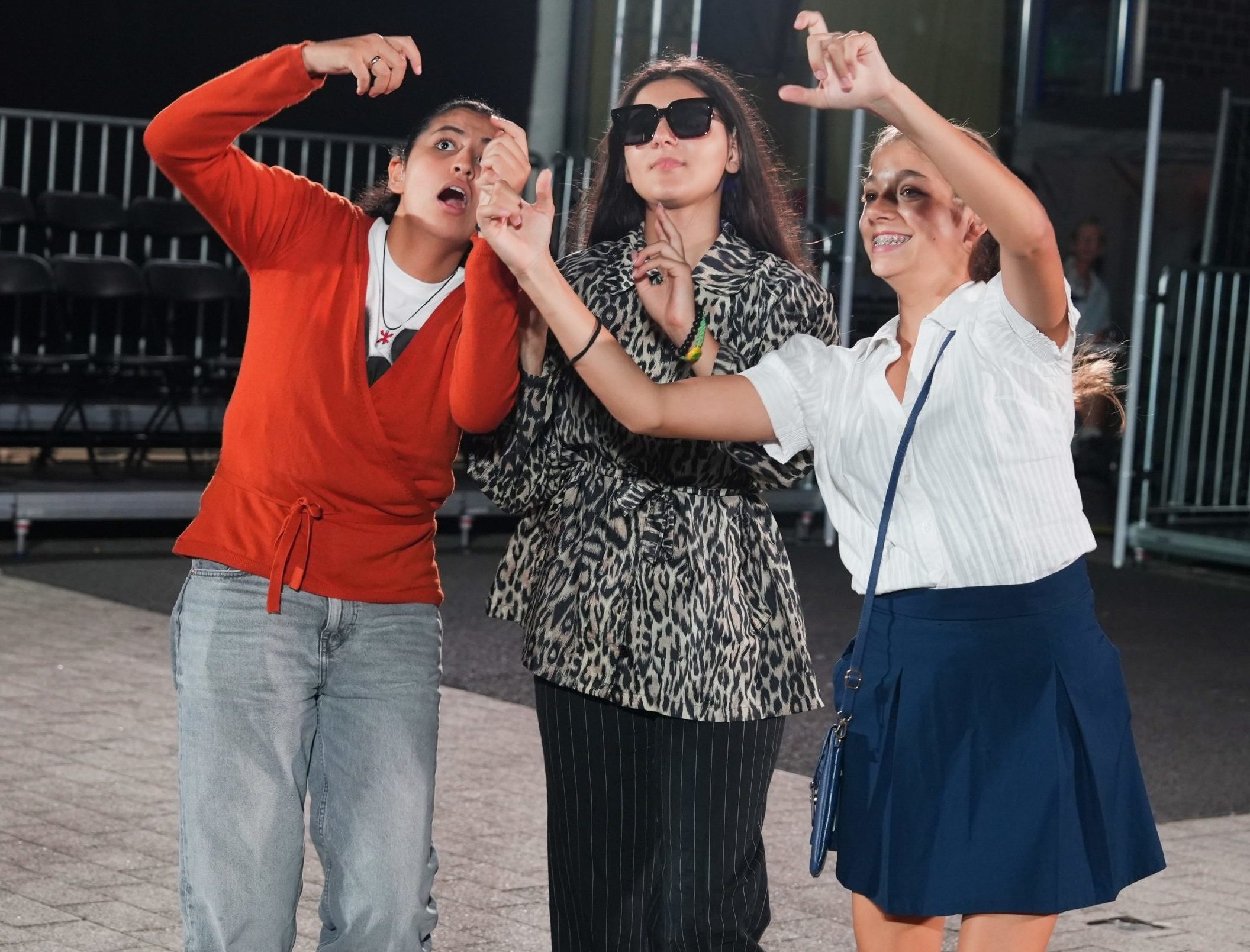 Drei Schülerinnen der Freiherr-von-Schütz-Schule bei der Aufführung. Die mittlere trägt eine Sonnenbrille. Die anderen beiden scheinen mit den Händen ein Selfie von ihr zu machen.