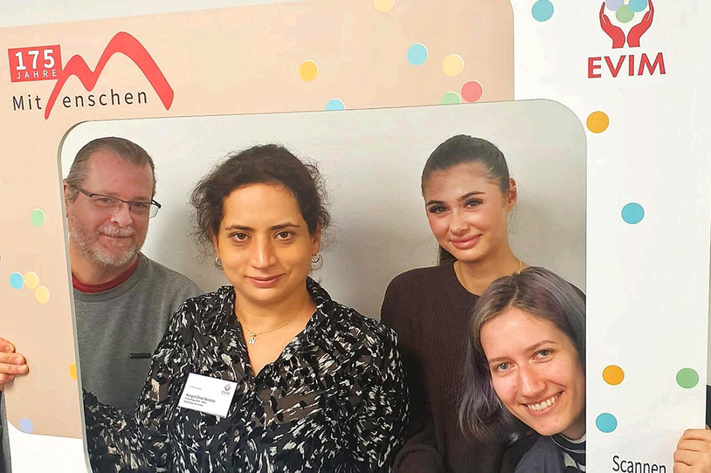 Vier Personen posieren lachend für ein Gruppenfoto.