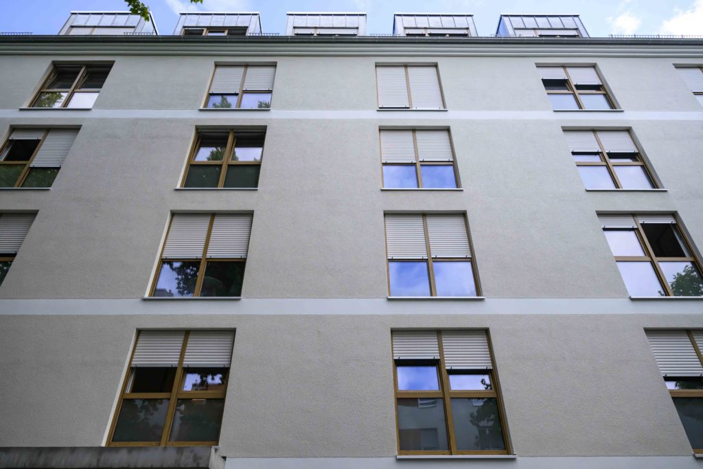 Eine weitere Außenaufnahme des Gebäudes zeigt zwei Fensterreihen mit jeweils vier Stockwerken und einem Dachgeschoss.