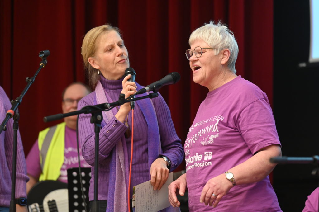 Eine Frau aus der Band wird von einer anderen Frau interviewt. Die Frau antwortet begeistert.