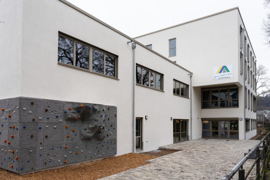 Die inklusive Jugendherberge in Marburg von Außen. Im Vordergrund eine graue Kletterwand.